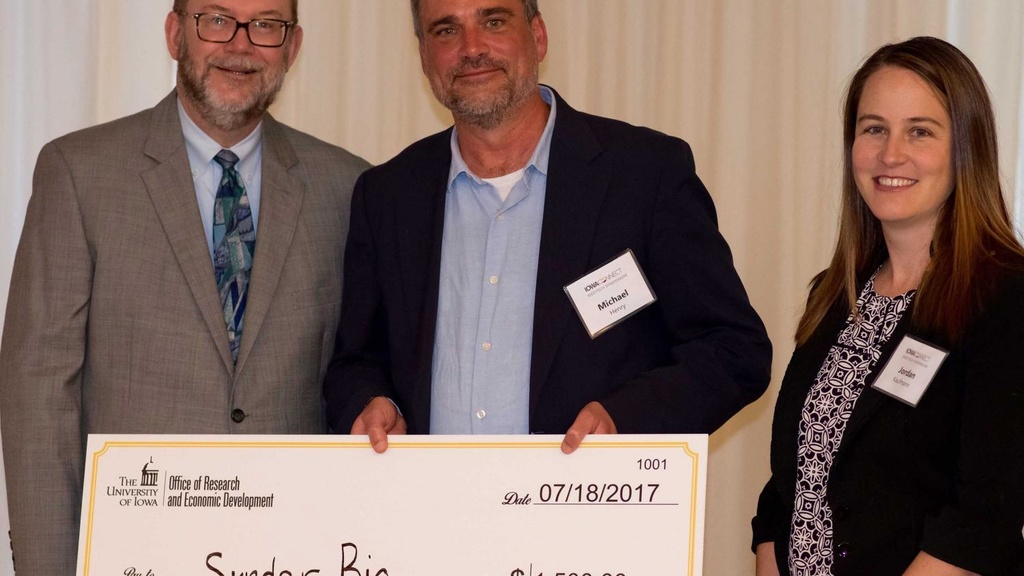 SynderBio's Michael Henry accepts check from Dan Reed and Jordan Kaufmann