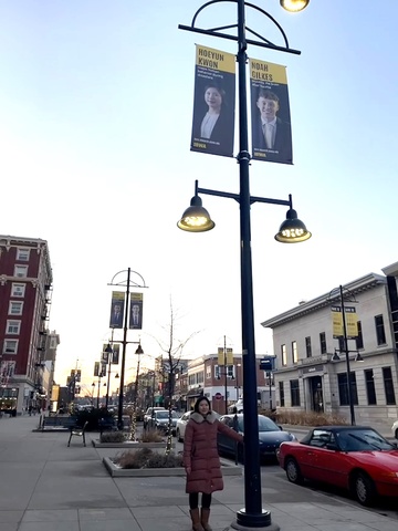 Hoeyun Kwon stands beneath her banner