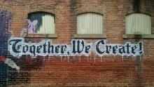 graffiti on brick wall that reads together we create!