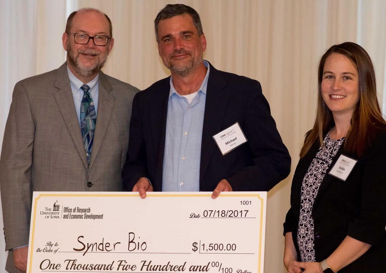 SynderBio's Michael Henry accepts check from Dan Reed and Jordan Kaufmann