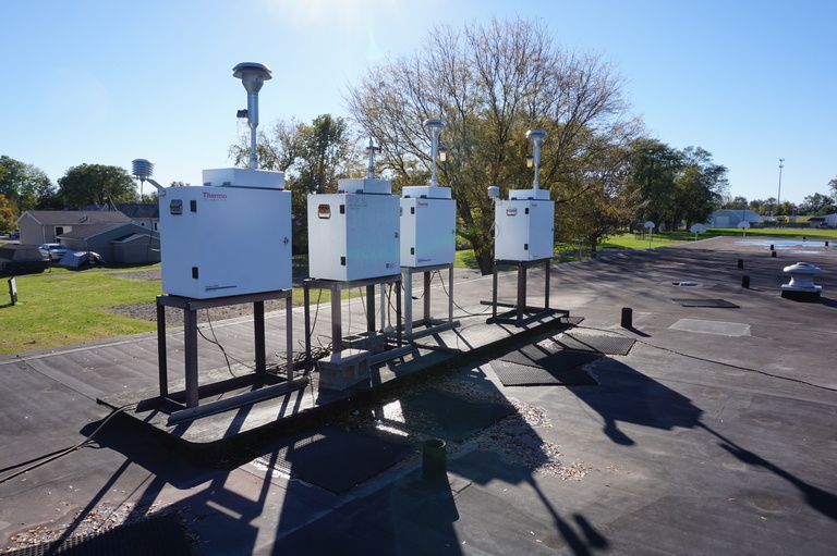 air monitoring instruments sit atop a school building air monitoring instruments