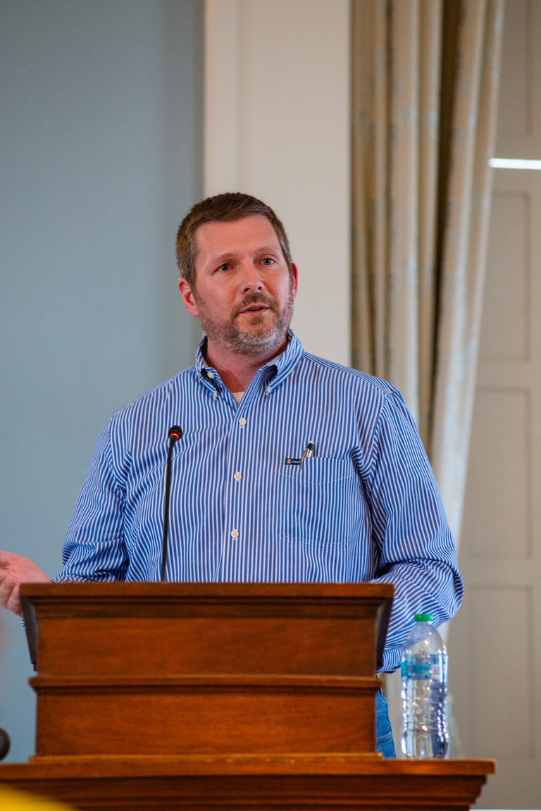 Scott Shaw speaking at the podium