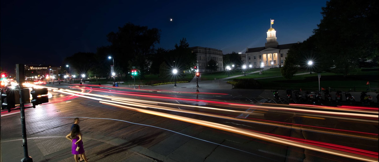 A photo capturing a street at night on the University of Iowa Campus