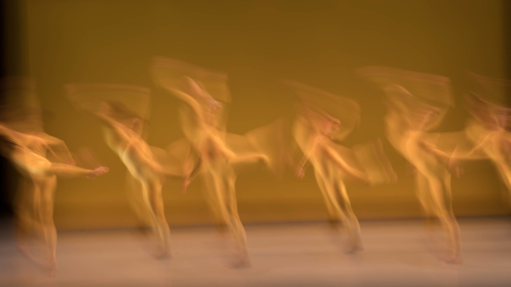 The image shows a dancer in motion, creating a dynamic and fluid visual effect.