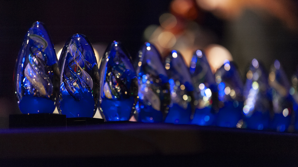 Row of blue glass trophies sparkle in the light